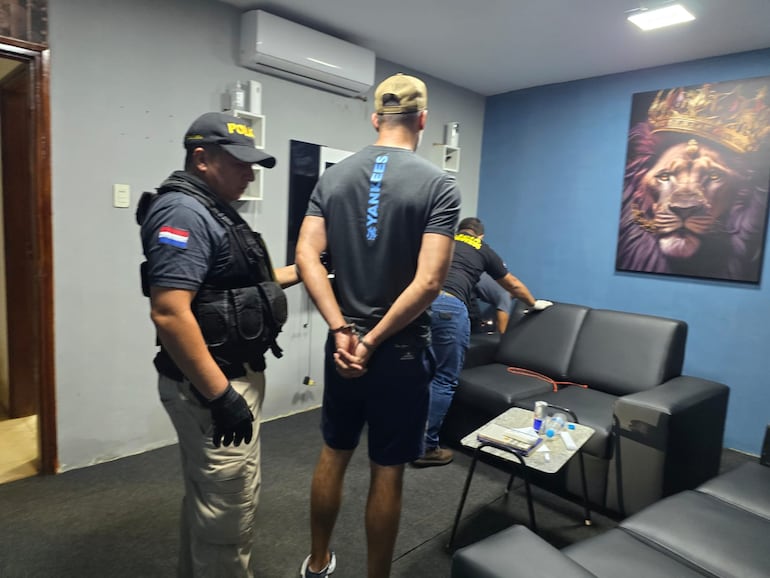 Agentes antidrogas inspeccionan el lugar allanado en presencia del detenido en Pedro Juan Caballero.