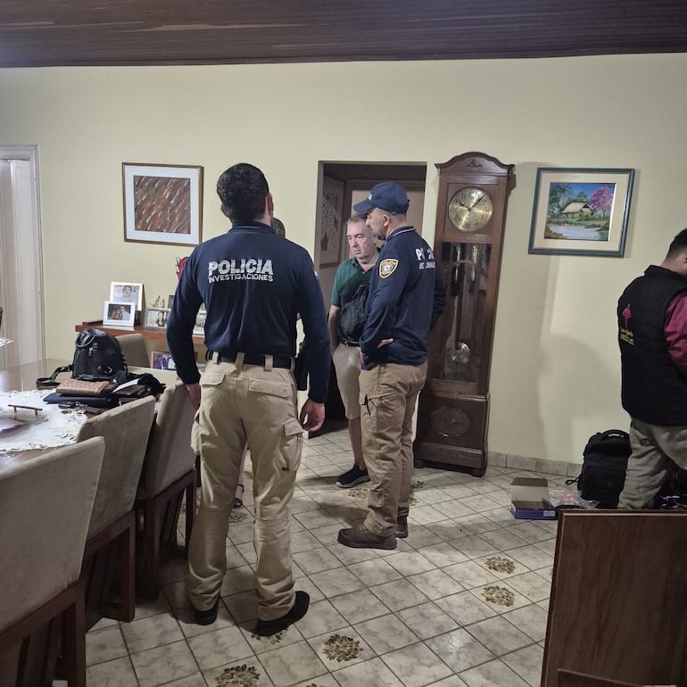 Agentes de la Policía conversan con uno de los afectados por robo domiciliario, en el barrio Los Laureles, de Asunción.