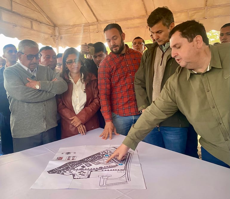 Santiago Peña en camisa verde claro señala un plano, mientras Isaías Ricardo Fretes observa atentamente en un ambiente colaborativo.