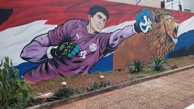 Mural de arquero con camiseta morada y león rugiendo en fondo de los colores de la bandera paraguaya.