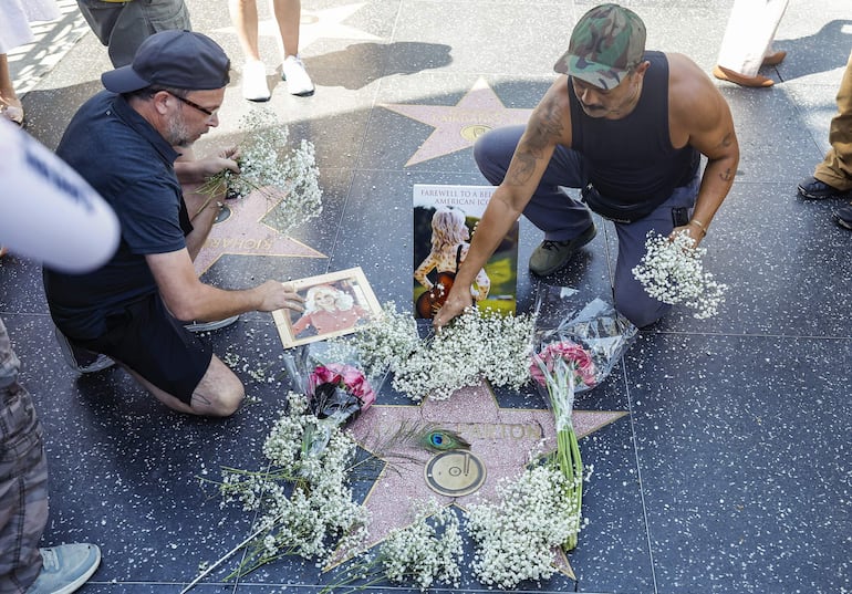 Fanáticos de Dolly Parton depositan flores y fotografías junto a su estrella en el Paseo de la Fama de Hollywood, tras conocerse la noticia de su fallecimiento. EFE/EPA/CHRIS TORRES