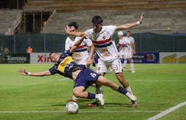 El extremo del 12 de Junio VH, Fabricio Portillo intenta conservar la posesión del esférico ante la marca del zaguero de Atlético Tembetary, Líder Cáceres. (Foto: @IntermediaAPF)