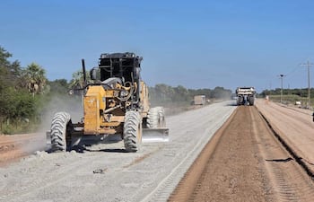 Maquinaria amarilla en construcción de ruta, con terreno en proceso y cielo despejado en un ambiente rural.