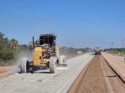 Maquinaria amarilla en construcción de ruta, con terreno en proceso y cielo despejado en un ambiente rural.