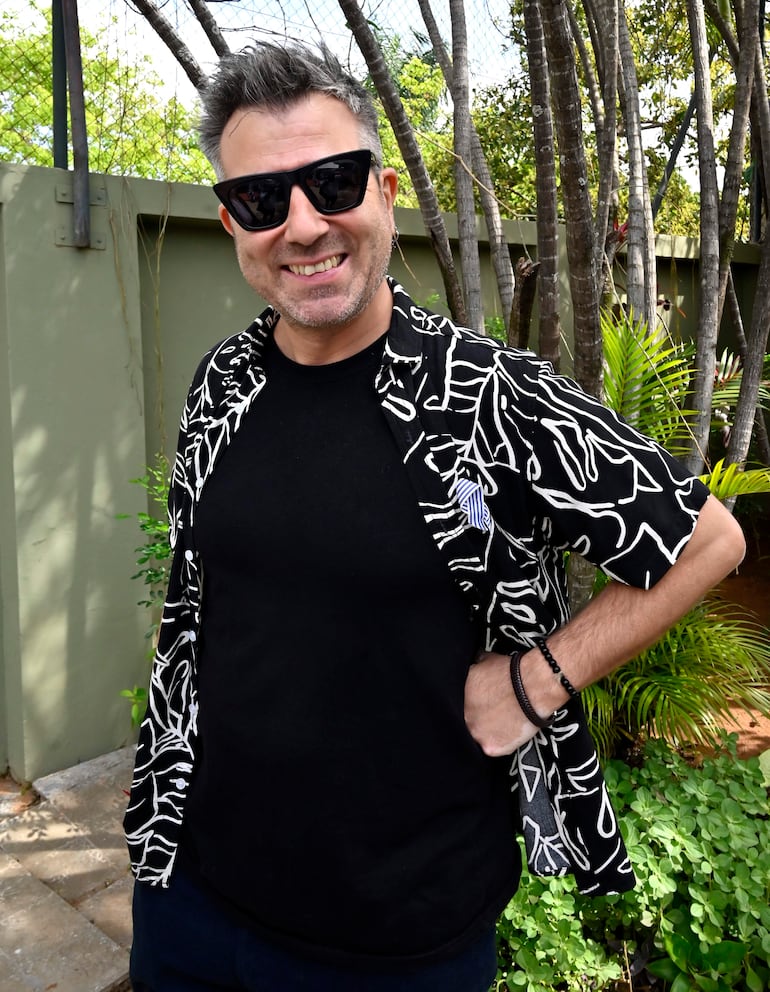 Mateo Moreno sonríe en una camisa abstracta y gafas de sol, en un entorno verde y relajado.