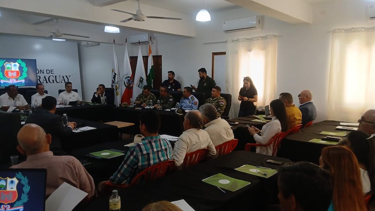 Federico Arturo Méndez González y Óscar González, en ambiente formal, discuten mientras otros asistentes toman notas y escuchan atentamente.