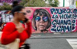 Una mujer pasa junto a un mural creado por Maca_dessine que representa a Gisele Pelicot y una frase que dice "Para que la vergüenza cambie de bando" en Gentilly, al sur de París. Los vídeos grabados por Dominique Pelicot de su mujer, Gisèle, cuando, inconsciente por las drogas que le suministraba, era violada por decenas de hombres a los que el marido invitaba a su casa, van a ser proyectados en el Tribunal de lo Criminal de Aviñón en presencia de público y de la prensa.