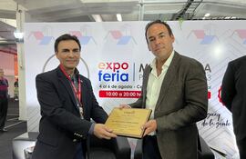 El titular del MUVH, Dr. Carlos Pereira, recibiendo la placa de distinción de Caprivi, por parte de su titular, Blas Reguera Riquelme, en el marco de la 2° Expo Mi Vivienda, en el Centro de Convenciones Mariscal.