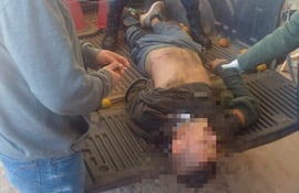 Escena de un enfrentamiento a tiros, con policías y civiles presentes en la calle, algunos visten ropa de uniforme y otros ropa civil.
