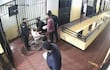 Hugo Javier en silla de ruedas, ensangrentado, rodeado por personal de seguridad y un adulto entregándole un objeto.