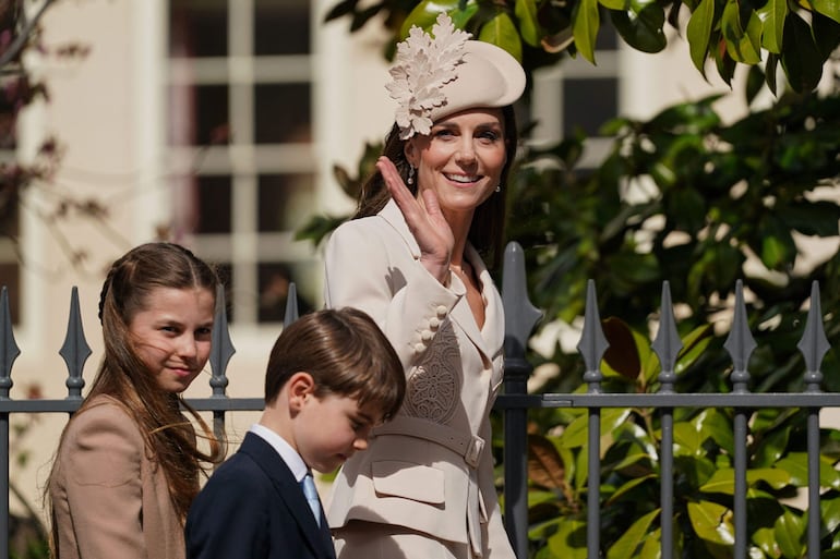 Kate Middleton saluda sonriente al llegar a la capilla de San Jorge junto a su hijos Charlotte y Louis. (Alberto Pezzali / POOL / AFP)