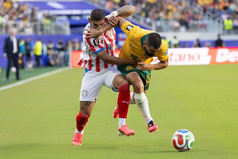 Juan José Cáceres de Paraguay y Aziz Behich de Australia en acción durante el partido de la fase de grupos de la Copa Mundial de la FIFA 2026 entre Paraguay y Australia, en Santa Clara, California, EE. UU..