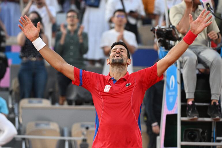 Novak Djokovic de Serbia celebra después de ganar contra Lorenzo Musetti de Italia (invisible) durante su partido semifinal masculino en las competiciones de tenis de los Juegos Olímpicos de París 2024, en Roland Garros en París (Francia), 02 de agosto de 2024.