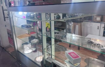 Escaparate de un local de celulares con diversos productos en exhibición, sin personas visibles en la escena.