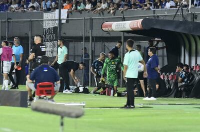 Gastón Olveira (verde), jugador de Olimpia, recibe asistencia médica a causa de una lesión en la rodilla izquierda durante el partido frente a Atlético Tembetary por la tercera fecha del torneo Apertura 2025 del fútbol paraguayo en el estadio Defensores del Chaco, en Asunción, Paraguay.
