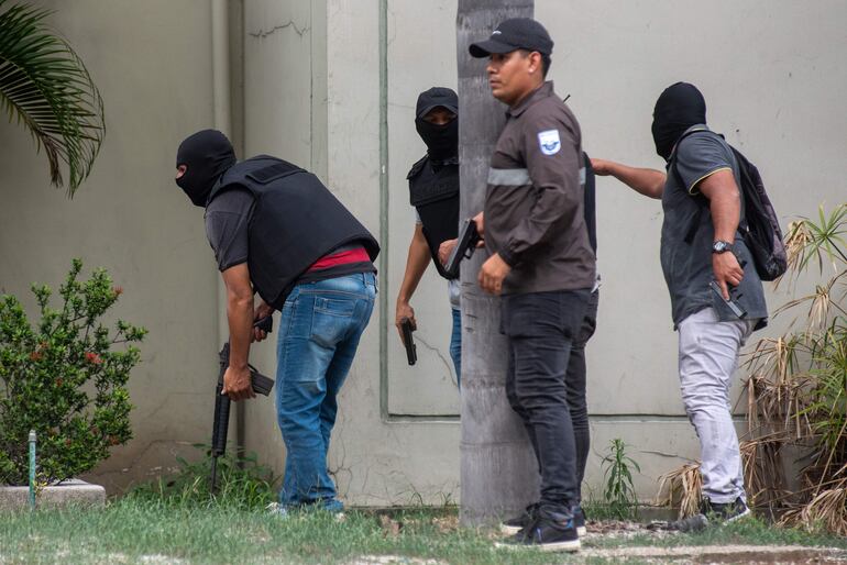 Policías realizando un operativo en la sede del canal de televisión TC, donde encapuchados armados ingresaron y sometieron a su personal durante una transmisión en vivo, en Guayaquil (Ecuador).