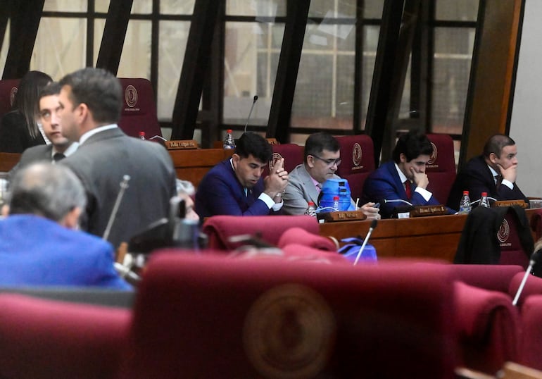 Adrian Vaesken y Pedro Gómez en el Congreso, con expresiones serias, revisando documentos en ambiente institucional.