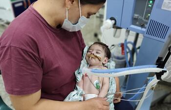La pequeña Ailana Milagros, en los brazos de su mamá, está internada en terapia intensiva desde setiembre de 2023.