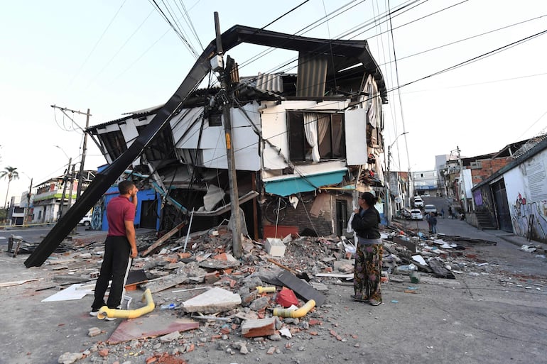 Una pareja permanece entre los escombros de una casa derrumbada tras un terremoto en Pereira, Colombia. Voluntarios y equipos de rescate colombianos retiraron escombros con las manos desnudas en busca de supervivientes durante la madrugada.