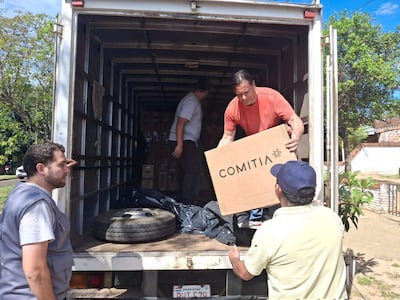 Funcionarios de la Justicia Electoral bajan del transporte las maquinas de votación.