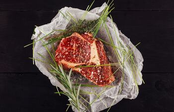 Carne de buey cruda con especias en papel de hornear.