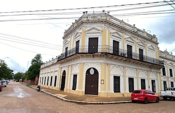 Edificio colonial amarillo del Obispado con balcones de hierro, rodeado de coches estacionados en un ambiente tranquilo.