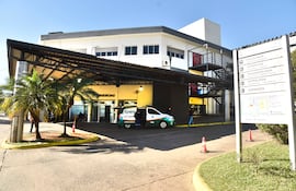Ambulancia de Epem en entrada del hospital, con árboles pequeños y letreros visibles de urgencias bajo un cielo claro.