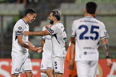 El delantero paraguayo de Independiente Rivadavia, Alex Arce, celebra con el defensor Juan Manuel Elordi, tras anotar durante el partido de la fase de grupos de la Copa Libertadores entre el Deportivo La Guaira de Venezuela e Independiente Rivadavia de Argentina, en el estadio Olímpico de la UCV en Caracas.