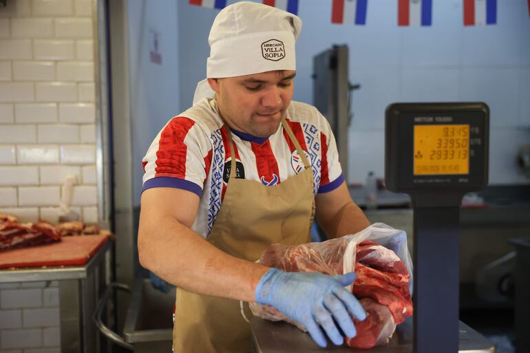 Un carnicero pesa cortes de carne el viernes, en Asunción, en la previa del partido contra Estados Unidos, en el cual Paraguay resultaría perdidoso.