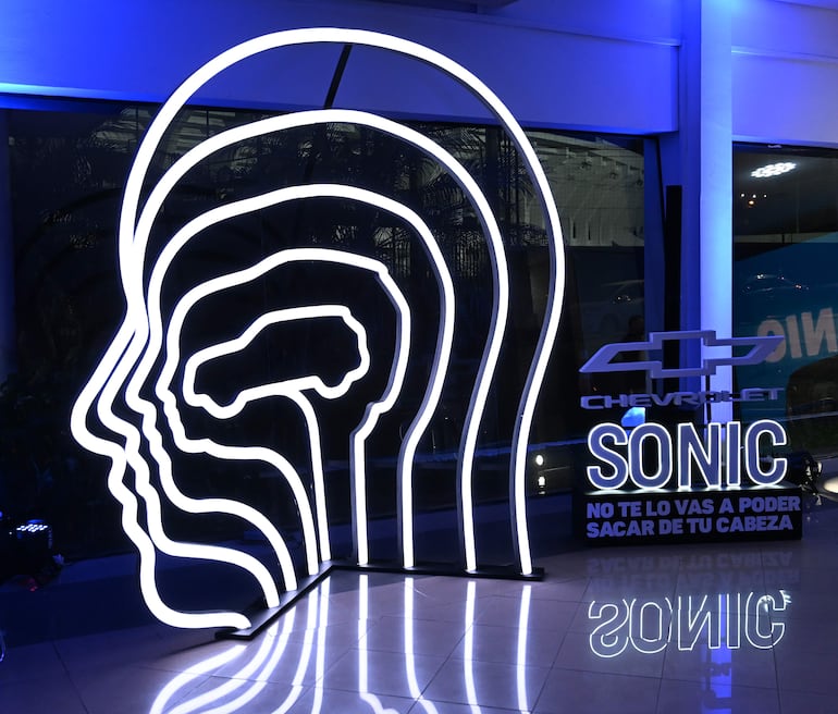 Estructura lumínica con forma de rostro y logo de Chevrolet Sonic iluminado en un evento promocional.