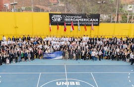 200 personas vestidas formalmente, con un cartel que dice 'FORO DE INVESTIGADORES' en una cancha de baloncesto.