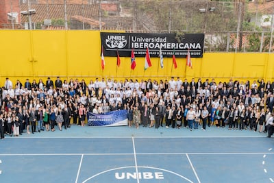 200 personas vestidas formalmente, con un cartel que dice 'FORO DE INVESTIGADORES' en una cancha de baloncesto.