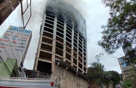 Una gran cantidad de humo sigue saliendo de los pisos superiores del edificio.