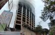 Una gran cantidad de humo sigue saliendo de los pisos superiores del edificio.
