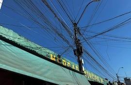 Vista del cielo con cables eléctricos enredados sobre el techo de una construcción en el Mercado 4 de Asunción.