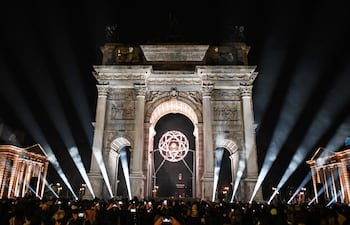 Multitudes se congregan antes de que la llama olímpica sea extinguida en el pebetero del Arco della Pace (Arco de la Paz), en Milán, norte de Italia, durante la ceremonia de clausura de los Juegos Olímpicos de Invierno Milano Cortina 2026, el 22 de febrero de 2026.