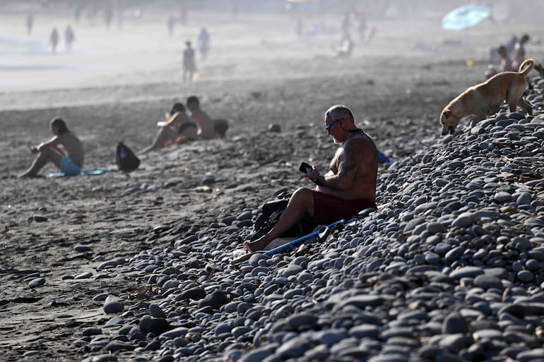 Los turistas se divierten al atardecer en la playa El Tunco, en La Libertad, El Salvador, el 13 de febrero de 2026.