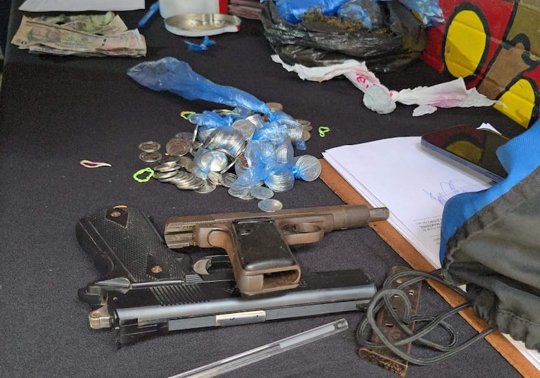 Dos pistolas, dinero y bolsas de plástico con monedas, elementos incautados durante un allanamiento antinarco en barrio San Juan, Asunción.
