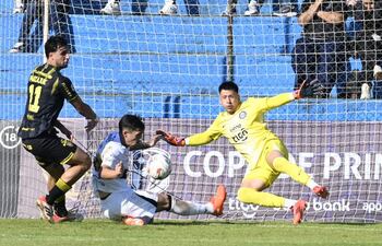 El portero de Olimpia, Sebastián Lentinelly interviene en medio del cruce de Juan Ángel Vera, ante la arremetida del atacante de Recoleta FC, Kevin Parzajuk.