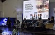 Seis panelistas en el conversatorio sobre energía, inversión y empleo, atentos en su atuendo formal, rodeados de un ambiente ordenado y banners informativos.
