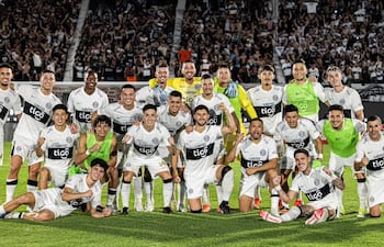 Los jugadores de Olimpia posan con la hinchada de fondo, tras el triunfo ante Nacional, en el encuentro disputado en el estadio Defensores del Chaco.