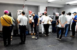 Personas hacen fila para cobrar sus aguinaldos en cajeros.