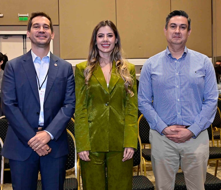 Estefanía Elicetche sonríe con traje verde, mientras Elías Saba viste camisa a cuadros y observa con expresión neutra.