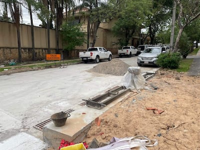 Calle en construcción con montículo de arena y cartel de 'CALLE CLAUSURADA', sin personas visibles.