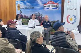 Jacinto Santa María, Alejandra Duarte y Antonio Carlos Barrios Fernández, atentos, lucen camisetas del rally en un evento decorado oficialmente.