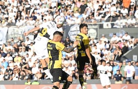 El goleador de Olimpia, Carlos Sebastián Ferreira se impone en el juego aéreo sobre los zagueros aurinegros, Alcides Barbotte y Sebastián Zaracho