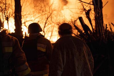 Bomberos frente a una casa en llamas luego de un ataque de drones rusos este sábado en Kiev.