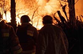 Bomberos frente a una casa en llamas luego de un ataque de drones rusos este sábado en Kiev.