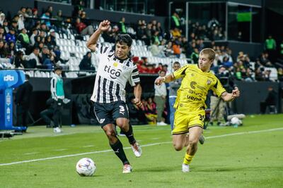 El defensor de Libertad, Robert Rojas intenta avanzar ante la marca del extremo de Recoleta FC, Giuseppe Guggiari.