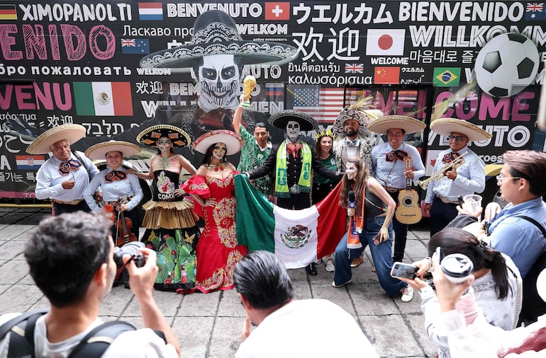 El Charro González y una mujer caracterizados como "Catrina" y grupo de mariachis, en México